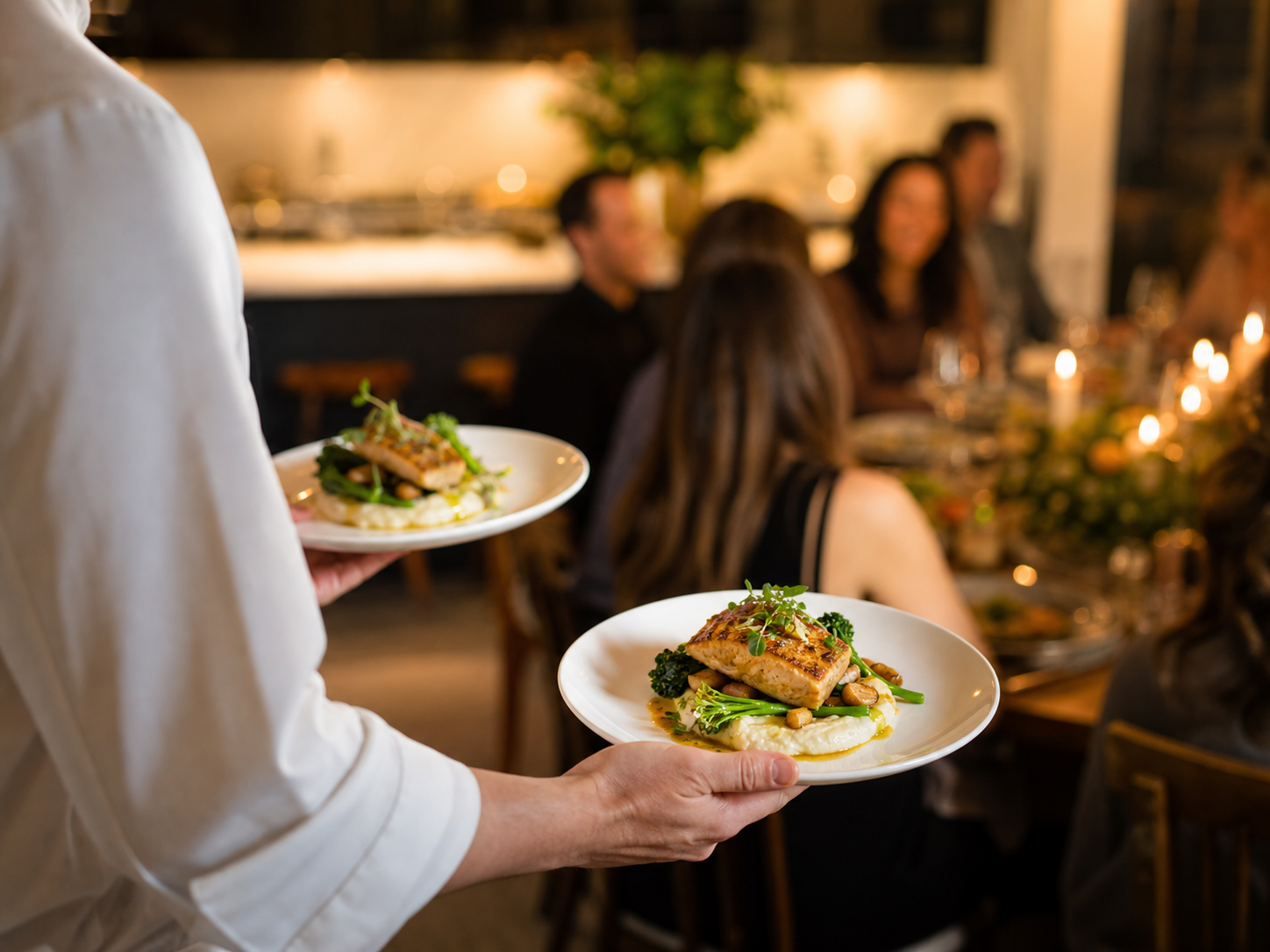 Private chef serving plates at a small dinner party